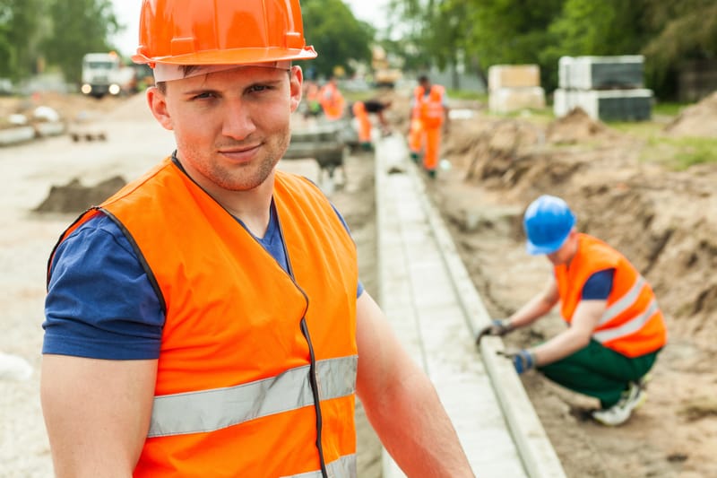A team of blue collar workers building on the roadside