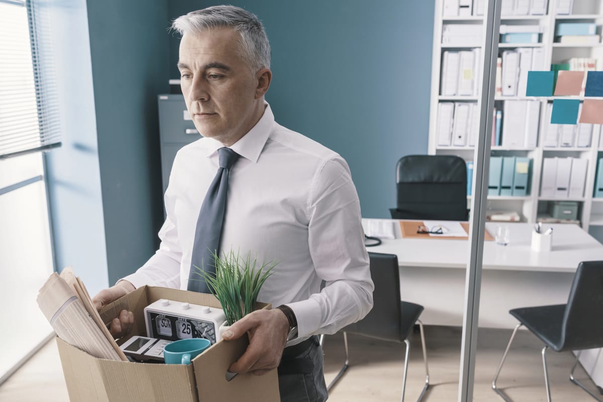 An employee carrying his items from his office after leaving a job
