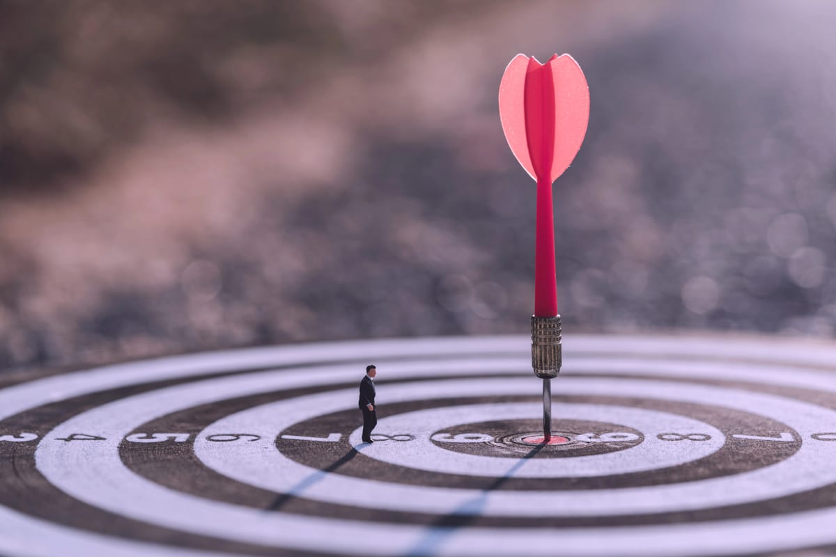 A dart board with a dart landing on the bullseye representing goal setting and achievement